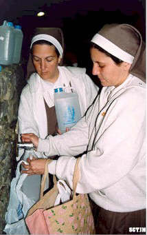 Nuestra fundadora y Sister Ana recogen agua de Lourdes